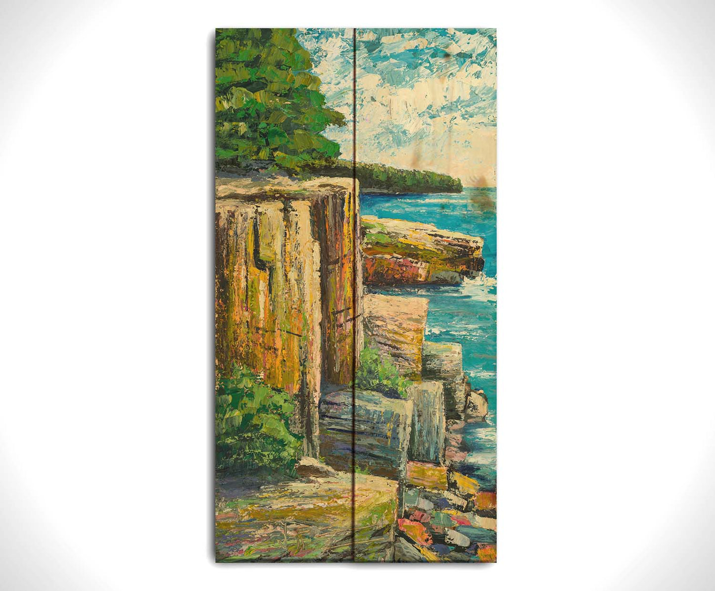 A painting overlooking a waterside clifface. Green forests grow across the tops of the cliffs, and the bright blue waters below splash against a colorful collection of rocks. Printed on a wood pallet.