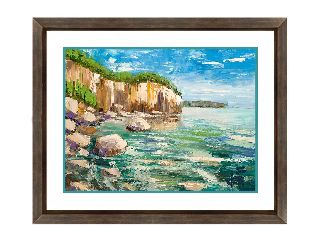 A painting of a rocky cliff overlooking clear waters on a sunny day. A vibrant green forest is growing on top of the cliffs. The teal water splashes against rocks on the shore. Printed on paper, matted, and framed.