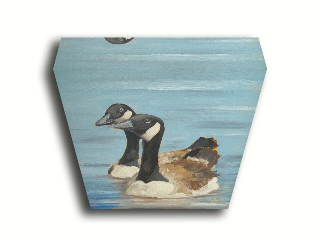 A painting of two Canadian geese swimming across smooth blue water. Printed on canvas.