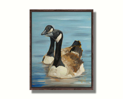 A painting of two Canadian geese swimming across smooth blue water. Printed on canvas in a float frame.