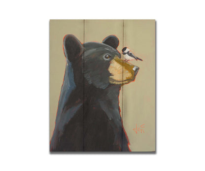 A portrait painting of a black bear, with a chickadee perched on its muzzle, set against a light brown background. Printed on a box board.