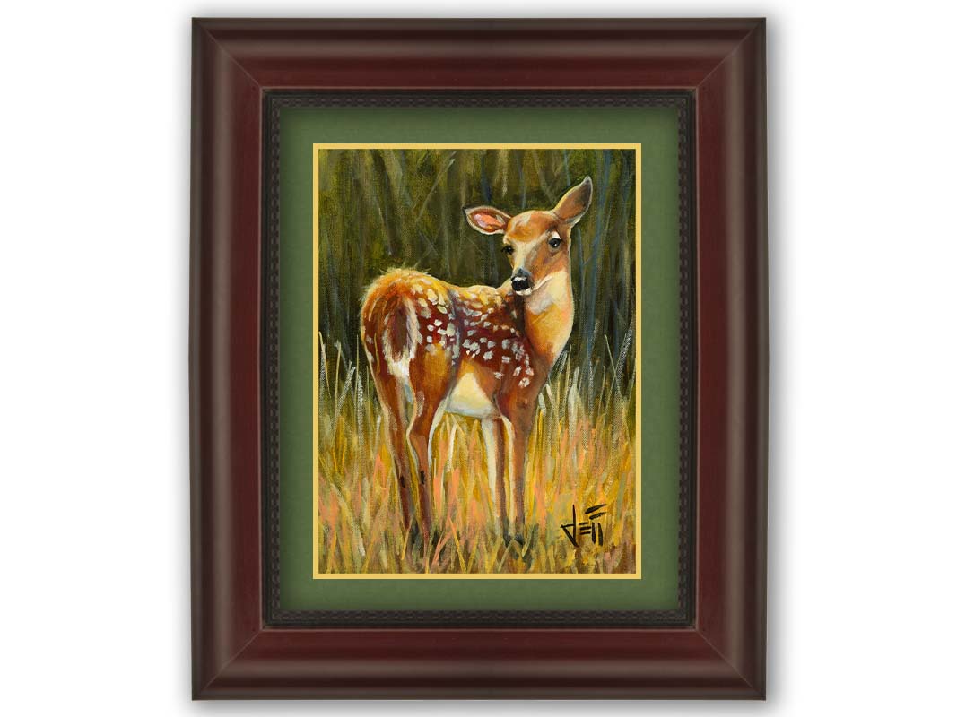 A painting of a baby deer, standing in a grassy field. before a green forest. Printed on paper, matted, and framed.