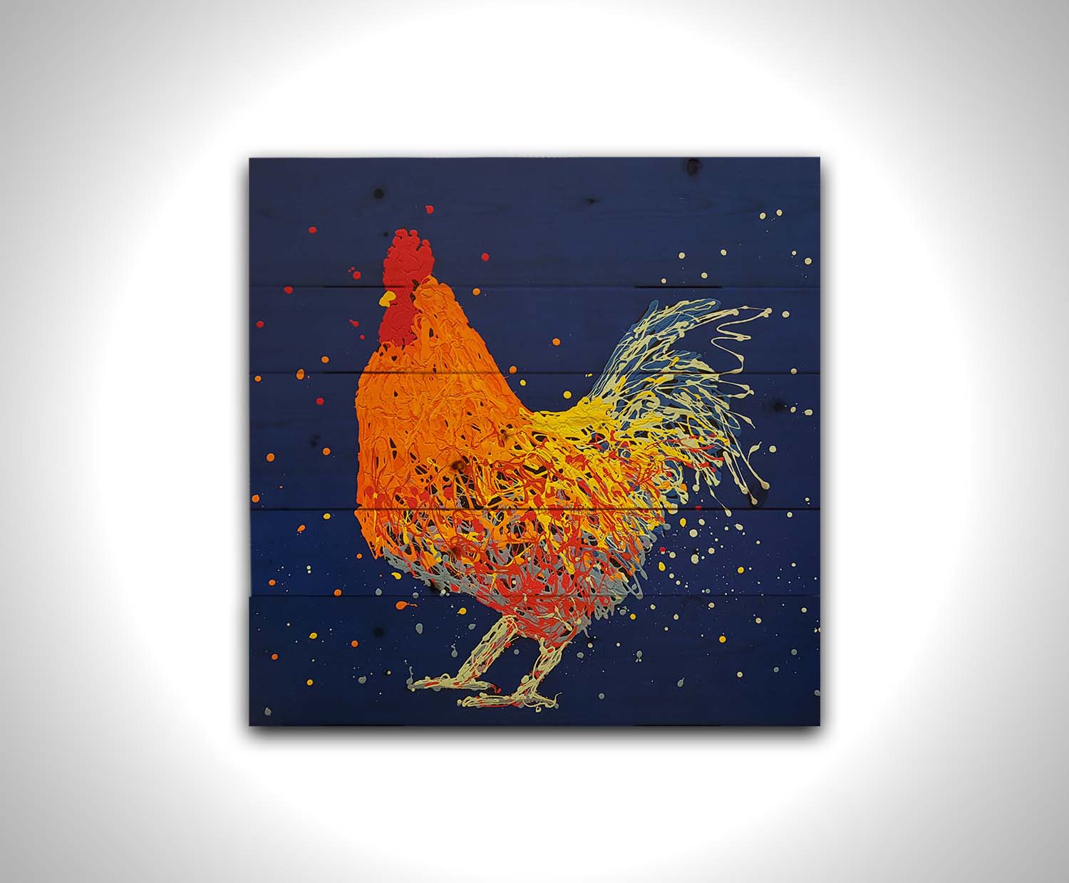 A drip painting of an orange rooster on a blue background. Printed on a wood pallet.