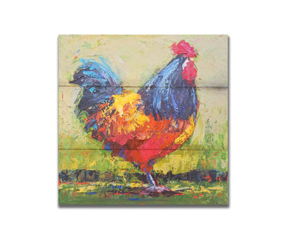 A painting of an orange and blue rooster in a green landscape. Printed on a box board.