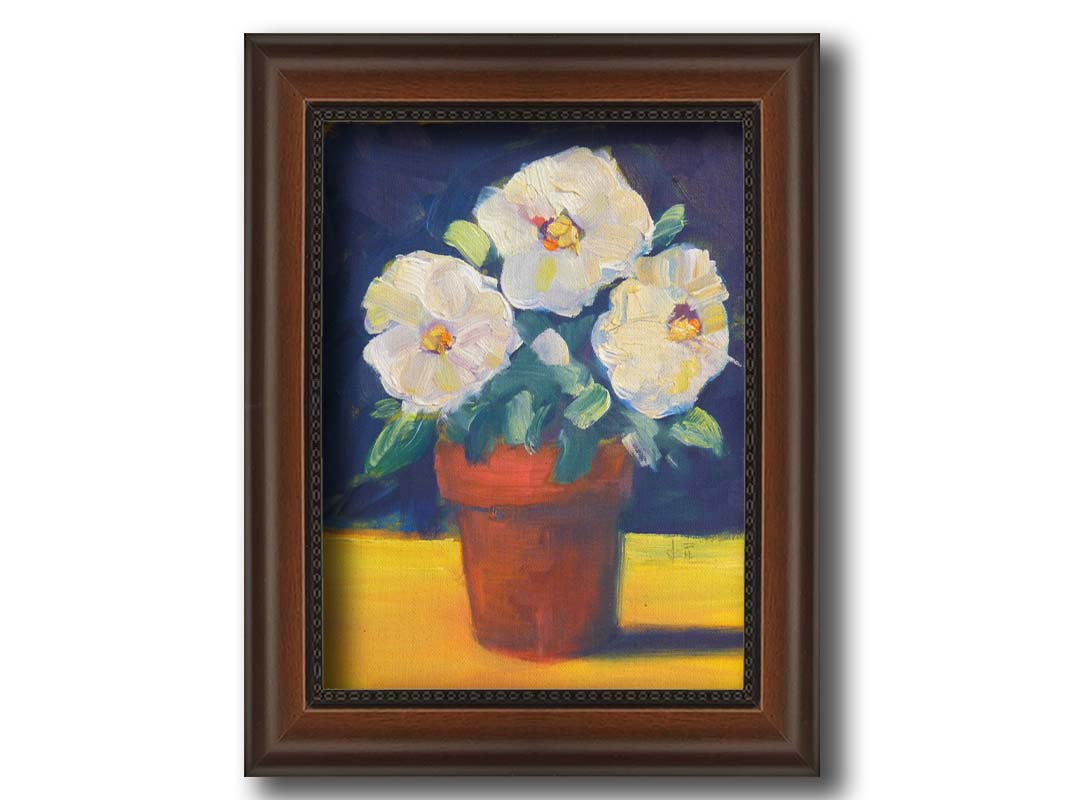 A painting of three white flowers in an orange clay pot. It is sitting on a yellow surface against a dark blue bathroom. Printed on canvas and framed.