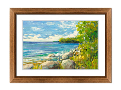 A painting of a calm bayside view. Bright green trees and foliage line the shore alongside smooth gray stones, and a blue sky with fluffy clouds reflects off smooth waters. Printed on paper, matted, and framed.