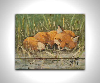 A painting of a red fox at peace, curled up and napping in a nest of green reeds by a tranquil pond. The contrasting colors of the reeds and the fox's fur create a stunning visual. Printed on a wood pallet.