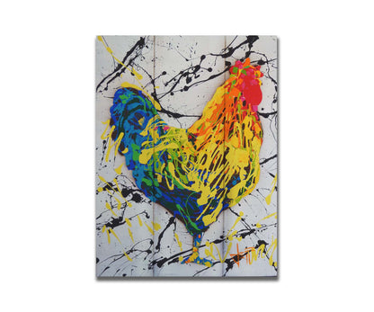 A drip painting of a rooster in red, orange, yellow, green, and blue set against a white background speckled with black and yellow. Printed on a box board.