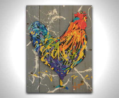 A drip painting of a rooster in a rainbow of colors, against a sleek gray backdrop, accented by white splashes. Printed on a wood pallet.