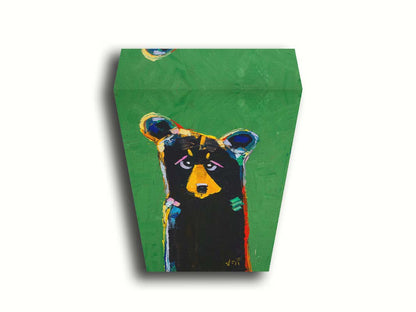 A stylized portrait painting of a black bear depicted as a simplified shape, accented by a spectrum of colorful outlines, and set against a bright green background. Printed on canvas.