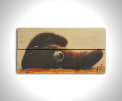 A painting of a fluffy brown bear rolled onto its back, arms outstretched, against a light neutral background. Printed on a wood pallet.