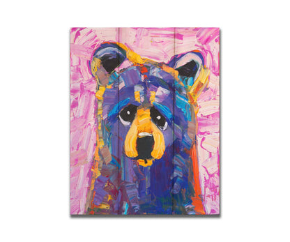 An impasto painting of a simplified, stylized bear in purples and pinks, accented with yellows in large, energetic brushstrokes. Printed on a box board.