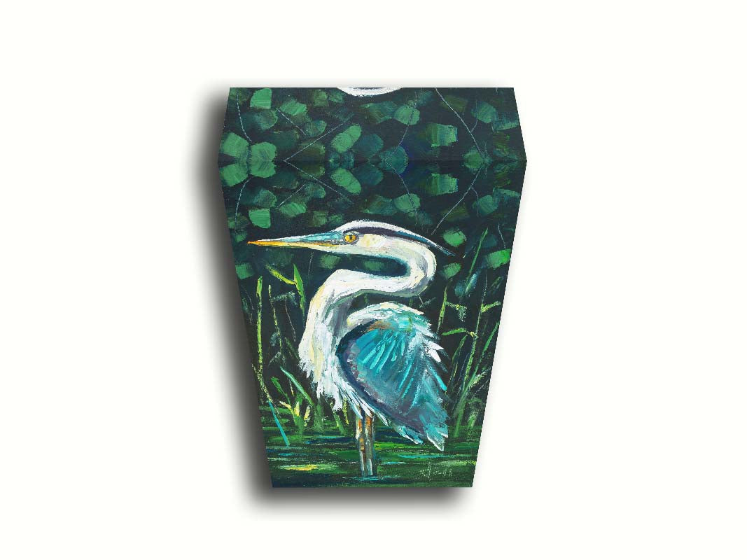 A painting of a great blue heron standing tall in a pond surrounded by vibrant foliage. Printed on canvas.