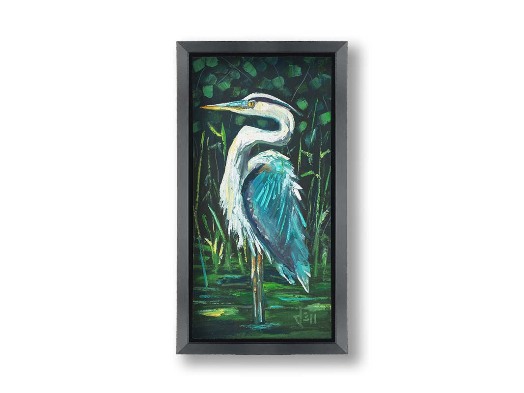 A painting of a great blue heron standing tall in a pond surrounded by vibrant foliage. Printed on canvas and framed.