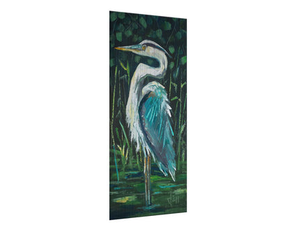 A painting of a great blue heron standing tall in a pond surrounded by vibrant foliage. Printed on metal.