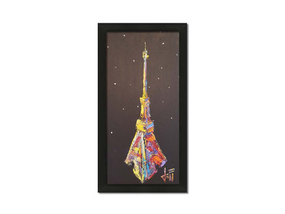 A painting of an abstracted rendition of the iconic Eiffel Tower in bright colors against a black background with white speckles. Printed on canvas and framed.