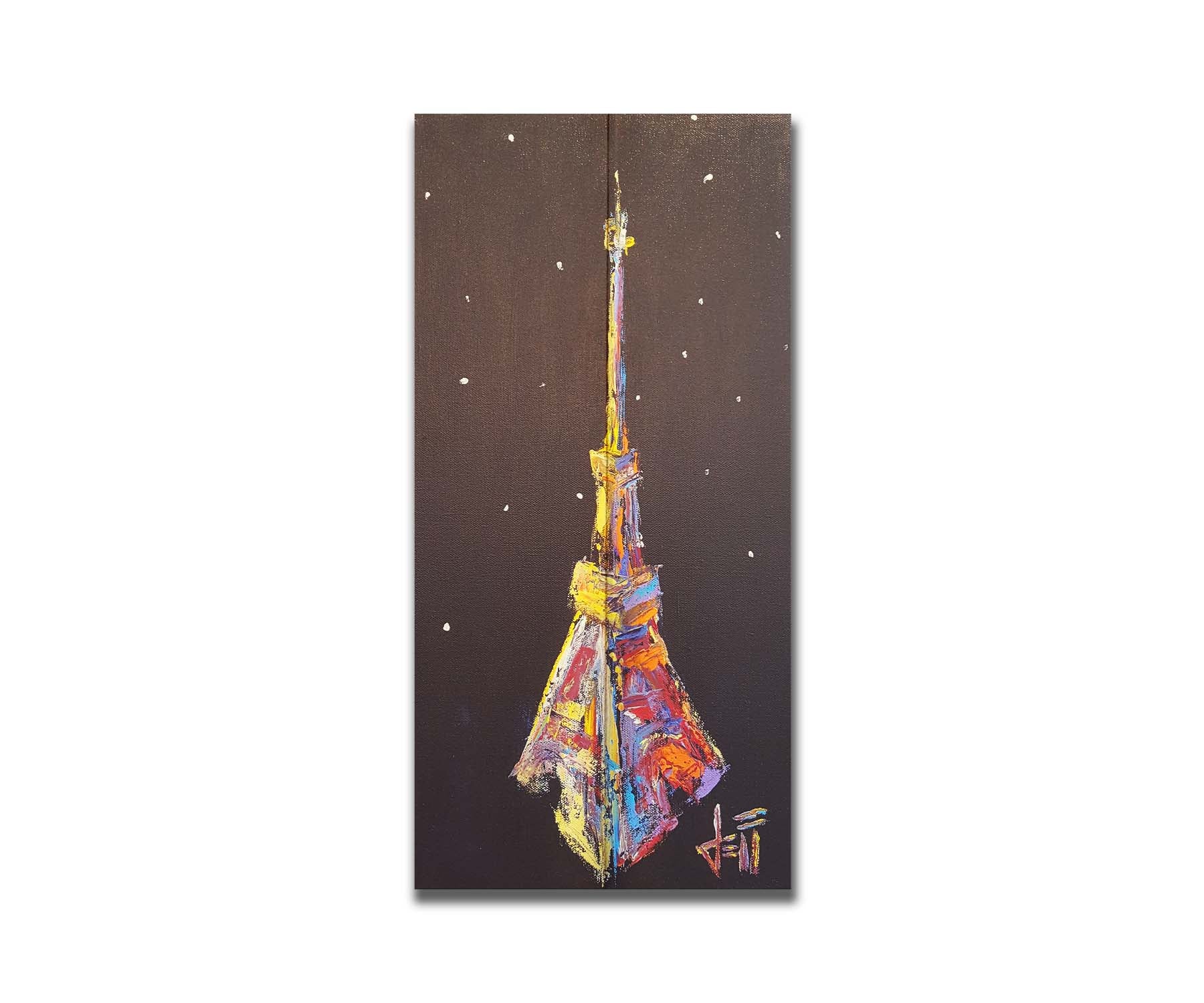 A painting of an abstracted rendition of the iconic Eiffel Tower in bright colors against a black background with white speckles. Printed on a box board.