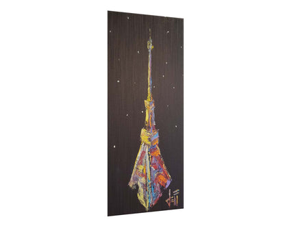 A painting of an abstracted rendition of the iconic Eiffel Tower in bright colors against a black background with white speckles. Printed on metal.