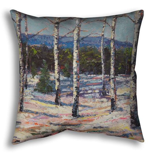 Throw pillow printed with a painting of birch trees in a snowy landscape with mountains in the background.