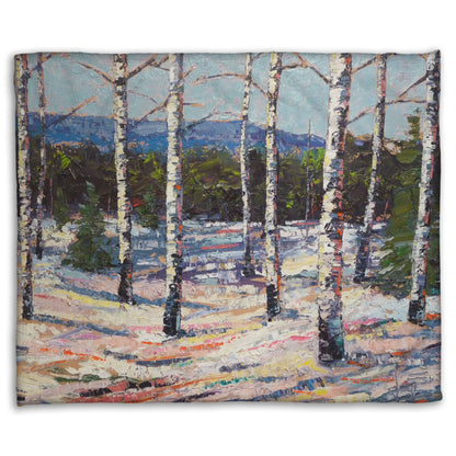 Coral fleece blanket printed with a painting of birch trees in a snowy landscape with mountains in the background.