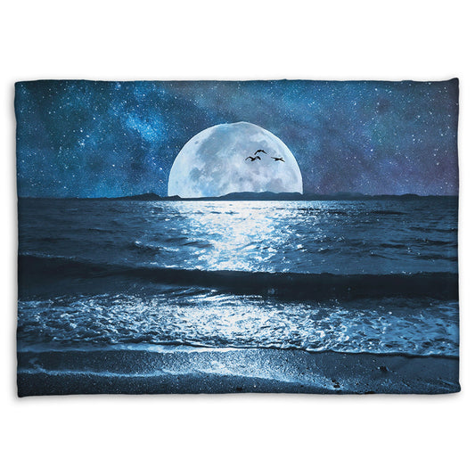 A coral fleece throw blanket designed with a photo of a full moon over the horizon of a calm, dark sea during a starry night.