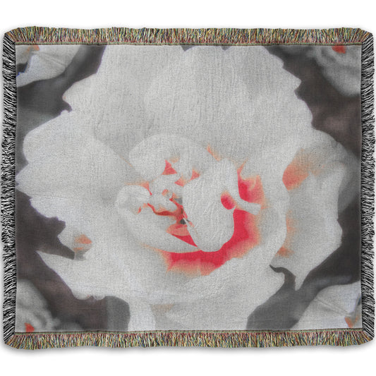 A woven throw blanket designed with a closeup photograph of a fancy tulip in grayscale, with one pop of pink and red in the center.