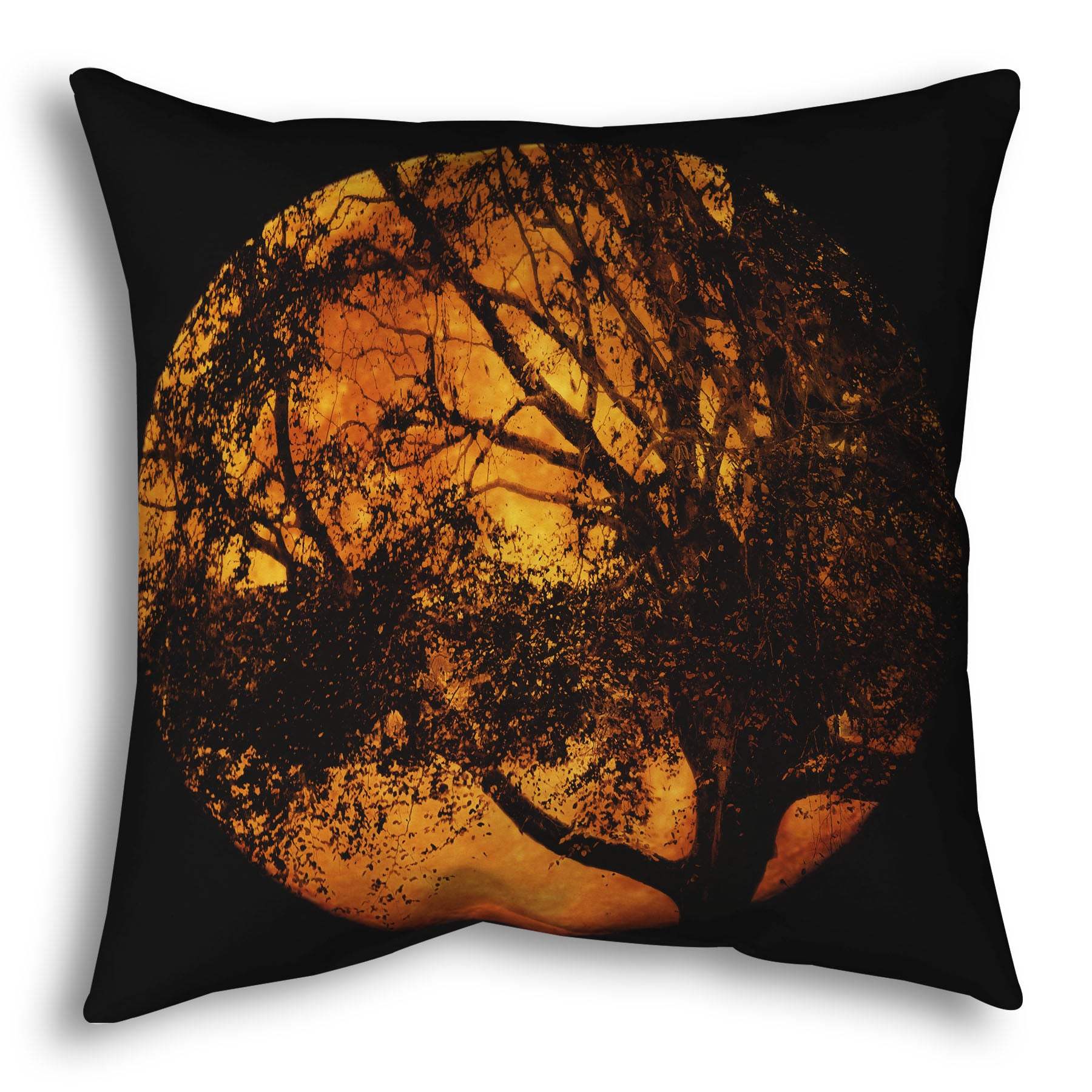 A throw pillow designed with a photo of the black shadow of a tree superimposed over a bright orange full moon.