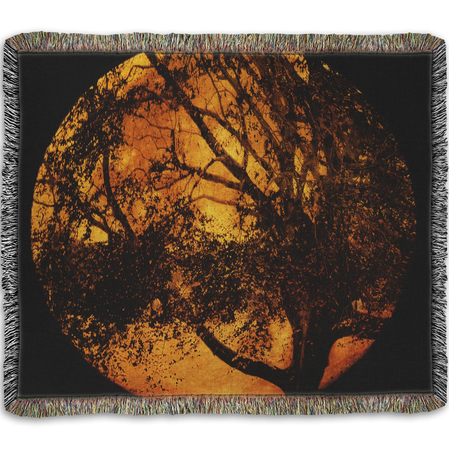 A woven throw blanket designed with a photo of the black shadow of a tree superimposed over a bright orange full moon.