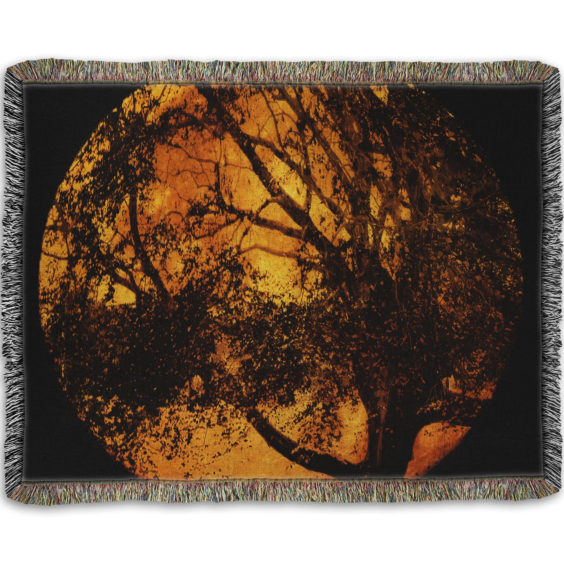 A woven throw blanket designed with a photo of the black shadow of a tree superimposed over a bright orange full moon.