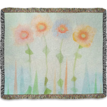 A woven throw blanket designed with an edited photo of flowers, the stems and background of trees illustrated to look like watercolor.