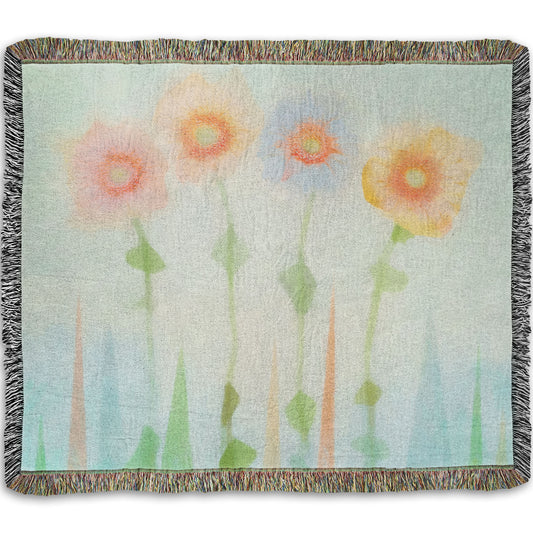 A woven throw blanket designed with an edited photo of flowers, the stems and background of trees illustrated to look like watercolor.