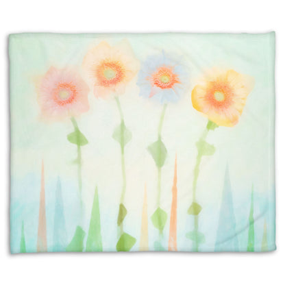 A coral fleece blanket designed with an edited photo of flowers, the stems and background of trees illustrated to look like watercolor.