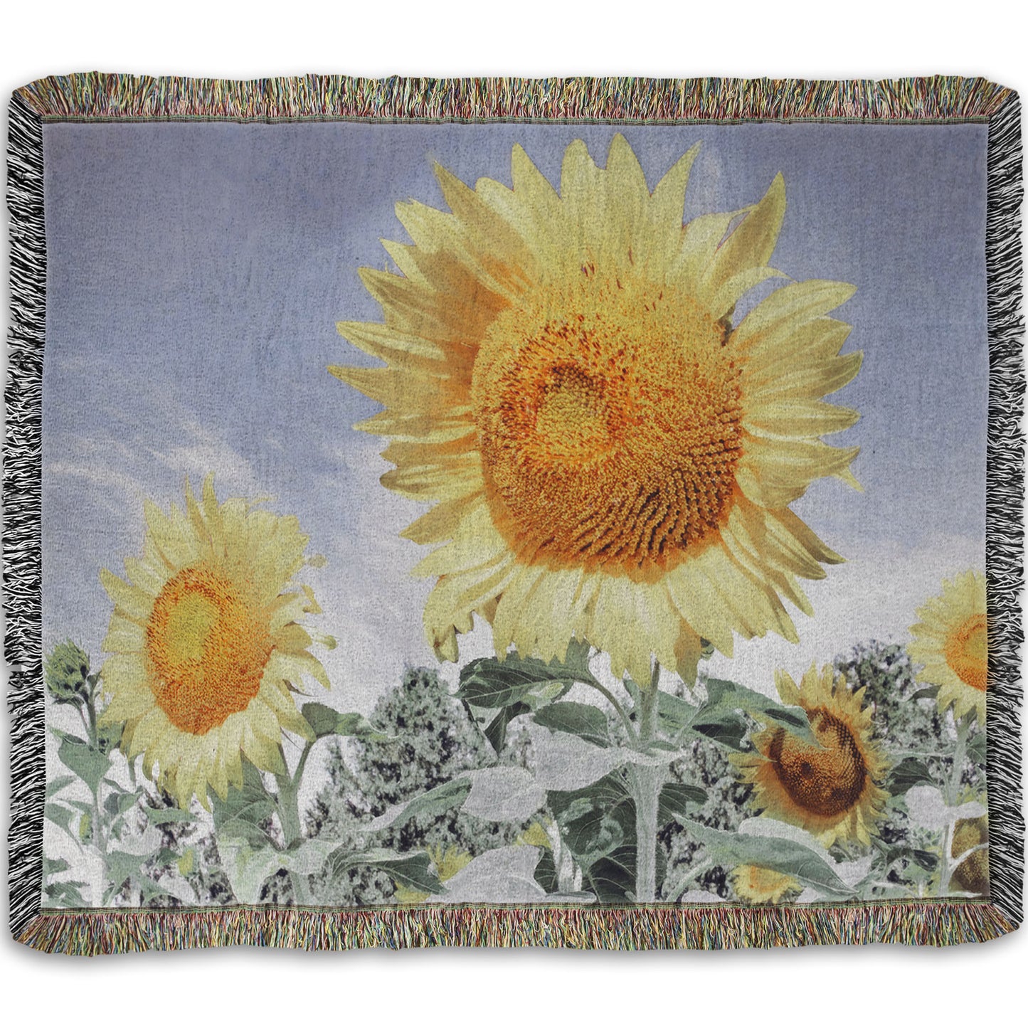 A woven throw blanket designed with a desaturated photo of a group of yellow sunflowers against a blue sky. 