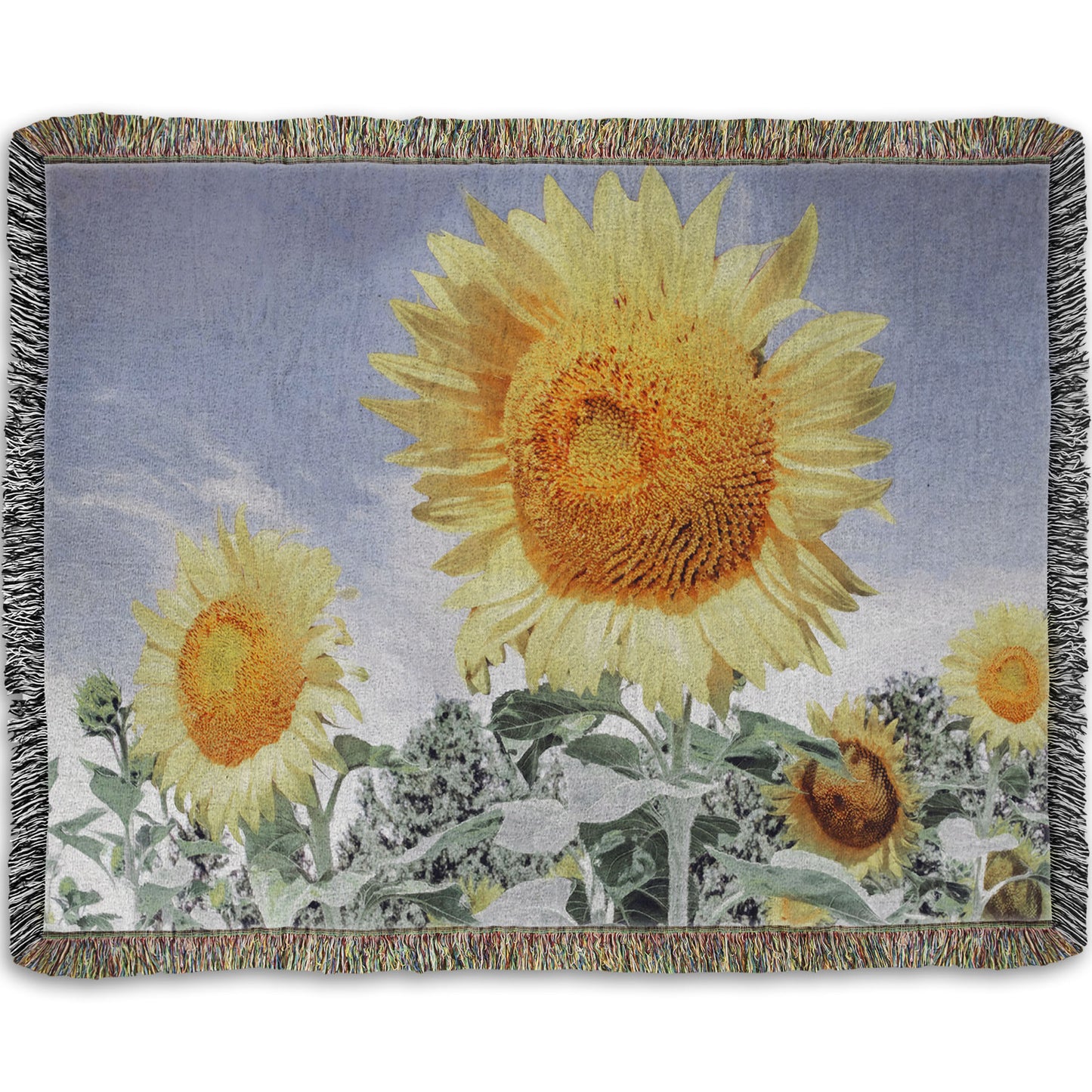 A woven throw blanket designed with a desaturated photo of a group of yellow sunflowers against a blue sky. 