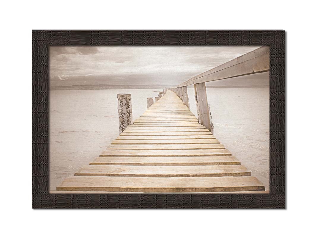 A photo looking along a pier out into the water, edited in a sepia tone. Printed on canvas and framed.