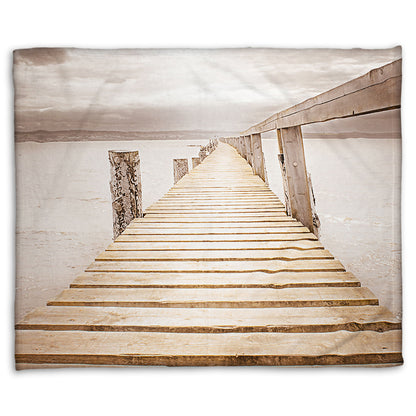 A fleece throw blanket designed with a photo looking along a pier out into the water, edited in a sepia tone.