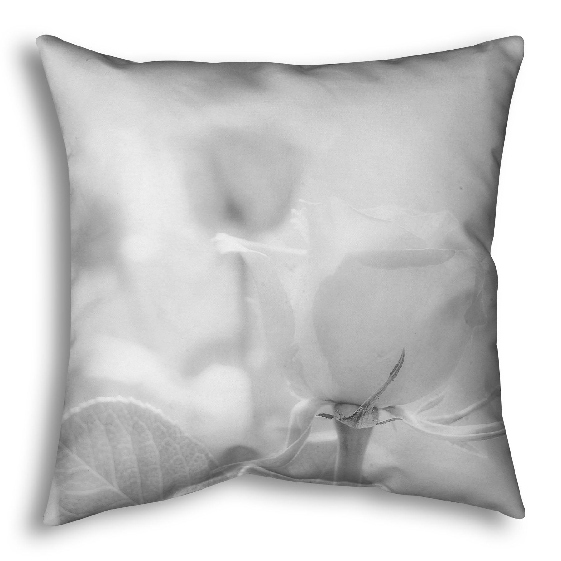 A throw pillow designed with a grayscale photo of three roses bathed in a soft white light. 