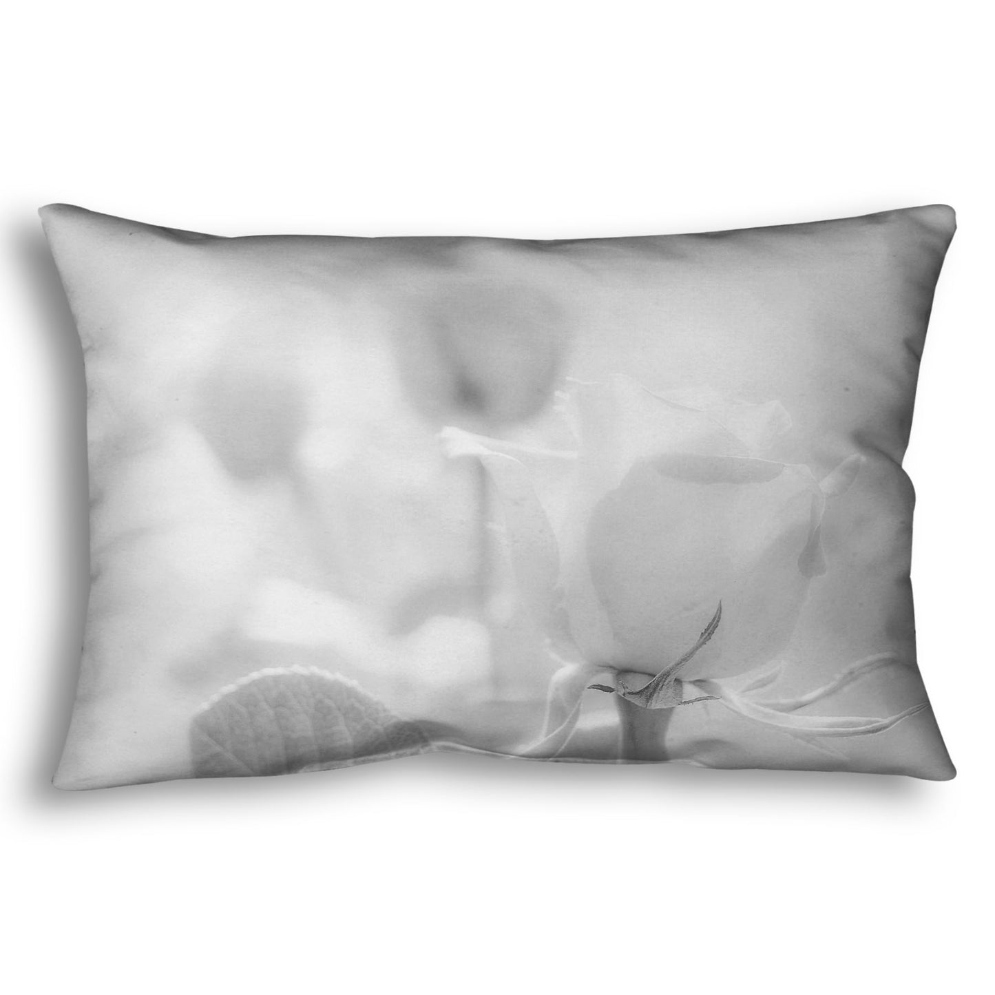 A throw pillow designed with a grayscale photo of three roses bathed in a soft white light. 