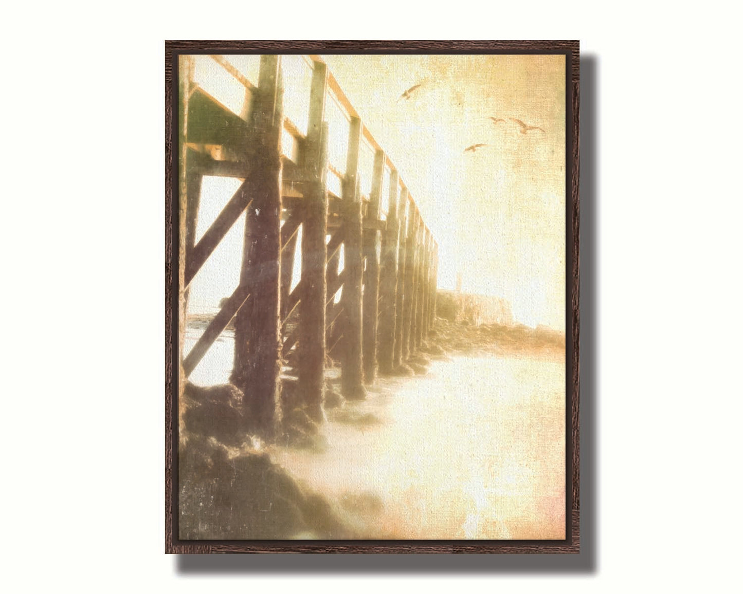 A sepia photo looking out to sea along the side of a pier, as seagulls fly above. Printed on canvas in a float frame.