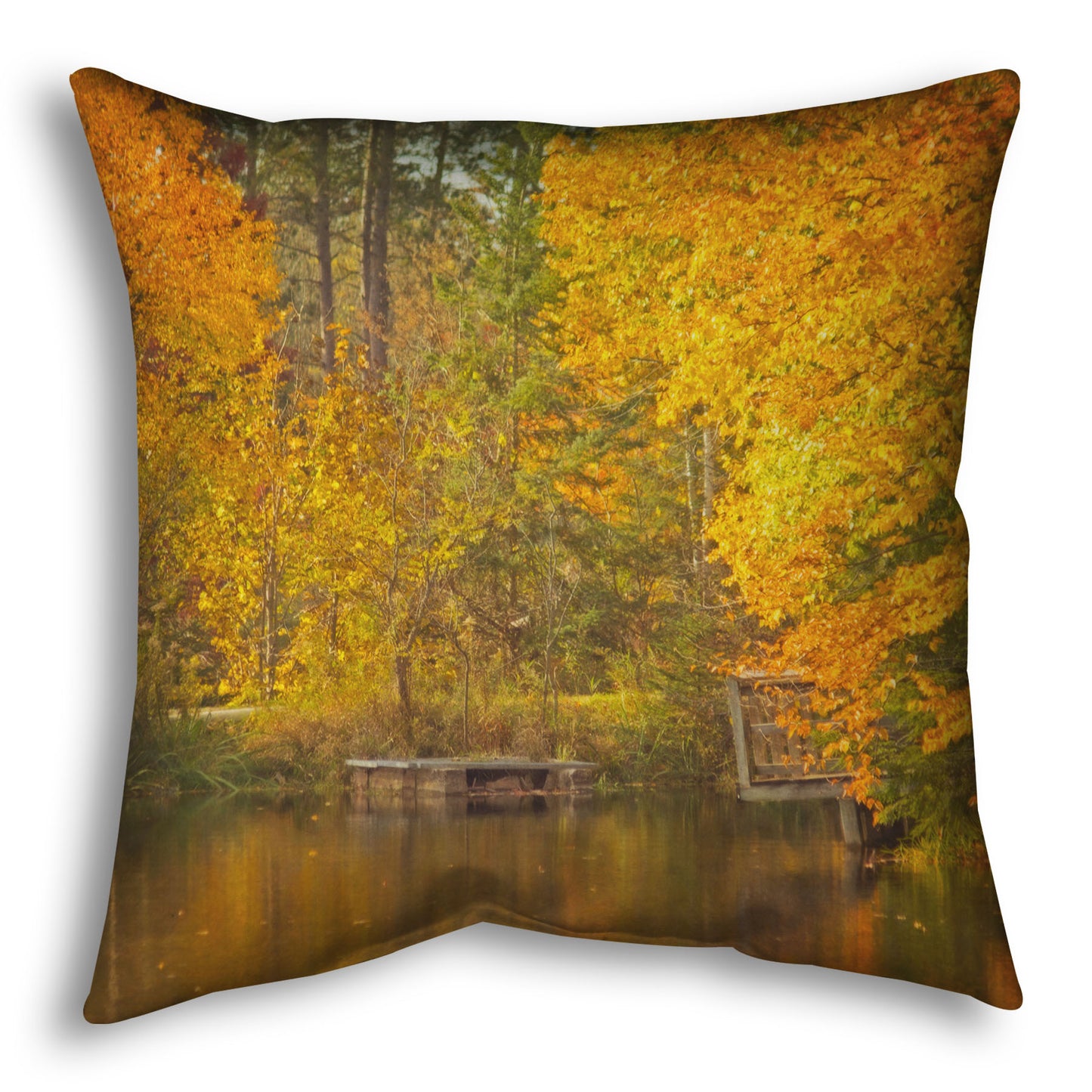 A throw pillow designed with a photo of yellow autumn trees at a pond, their leaves reflecting off the water. 