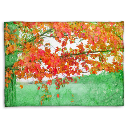 A fleece blanket designed with a photo of a tree's red leaves. The rest of the image has been edited green.