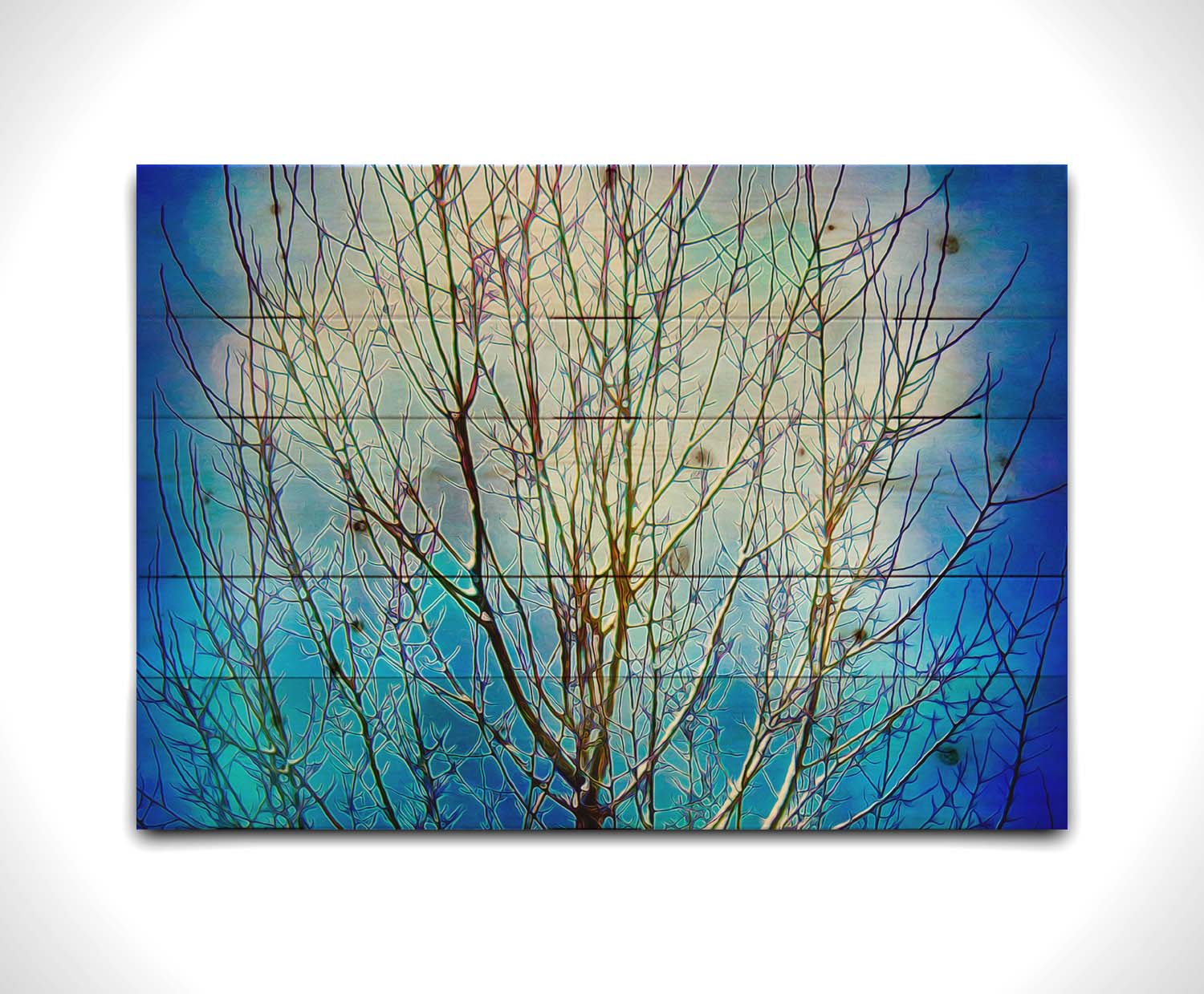 A photo looking up at a leafless tree against a bright blue sky, edited to have a painterly quality. Printed on a wood pallet.