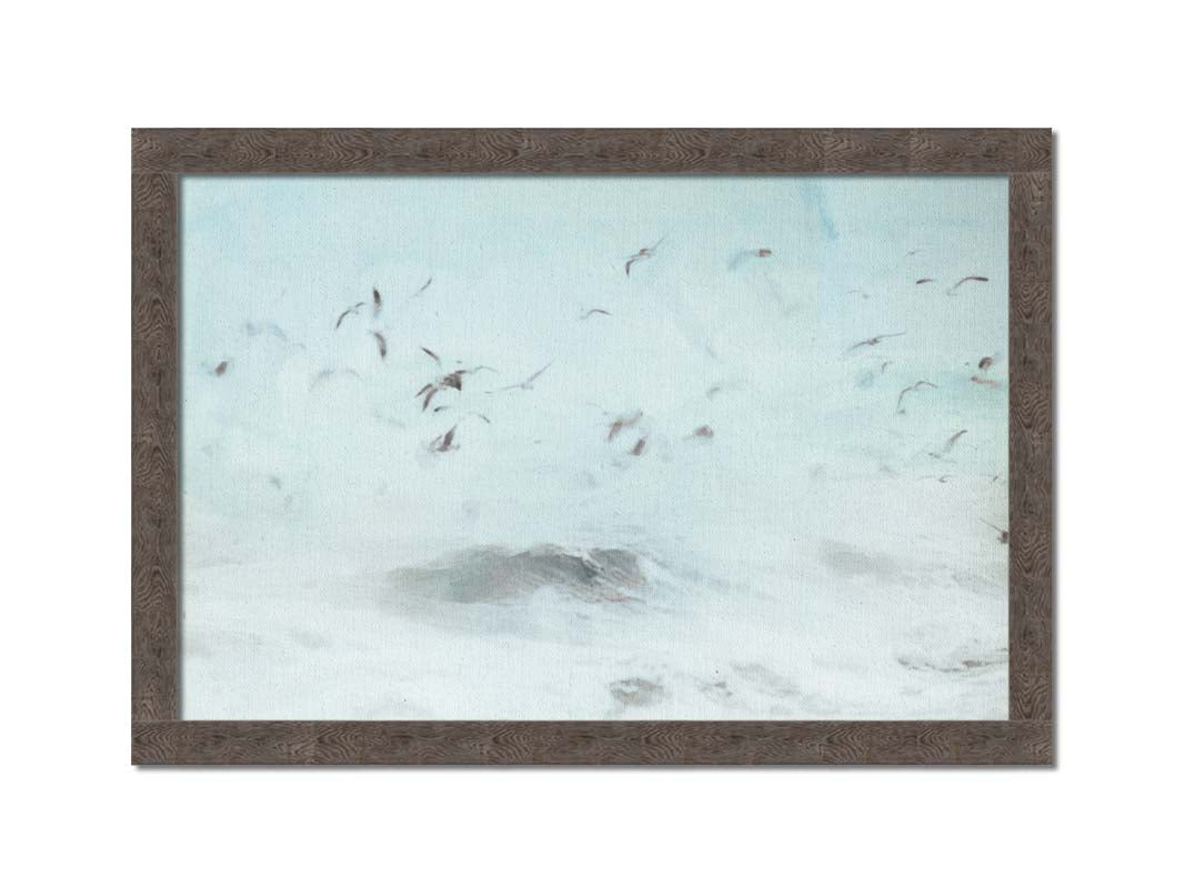 A photo edit of birds flying low over the stormy ocean, searching for a meal. Printed on canvas and framed.