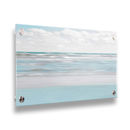 A photo of the ocean, and the line formed at the horizon where its color cuts across the sky of fluffy, white clouds. Printed on acrylic.