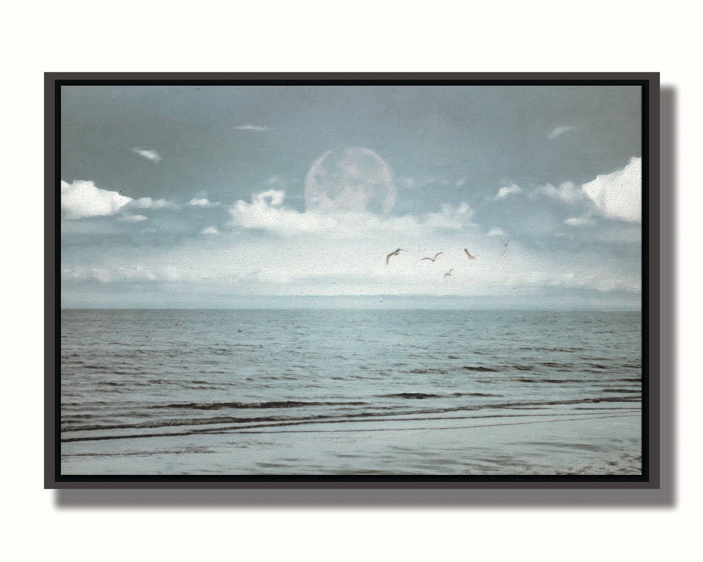 A photo of a pale blue sea with a lage moon on the horizon. Printed on canvas in a float frame.