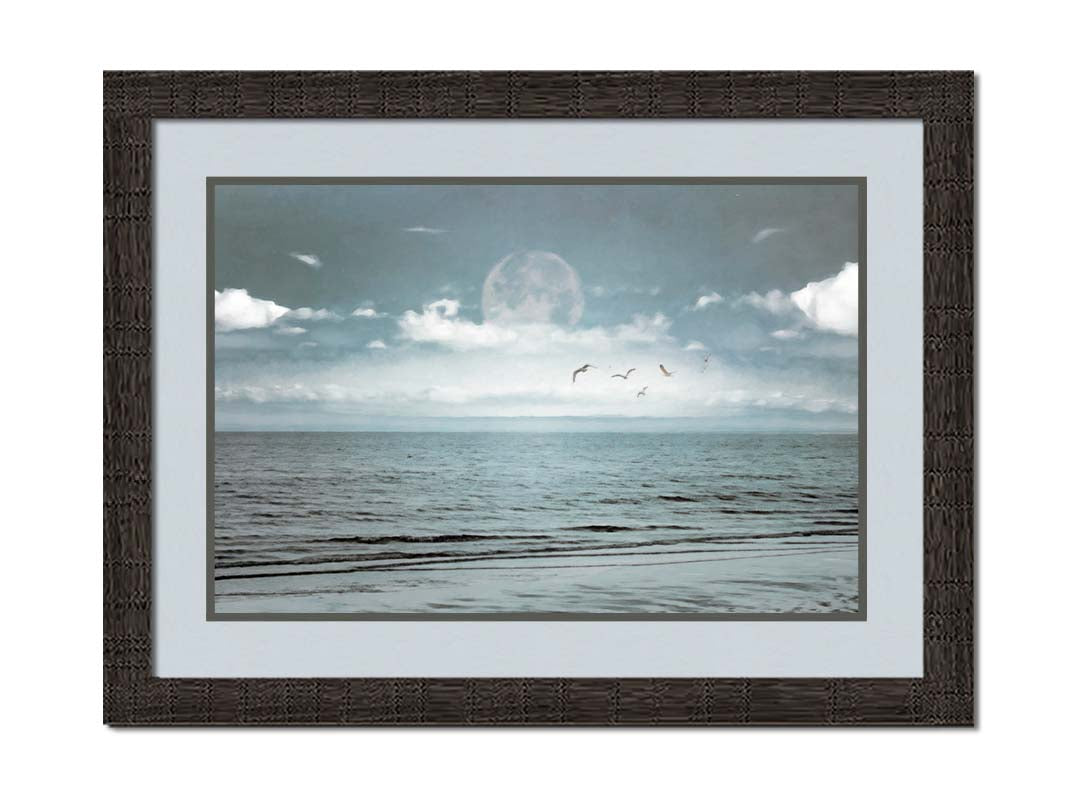 A photo of a pale blue sea with a lage moon on the horizon. Printed on paper, matted, and framed.