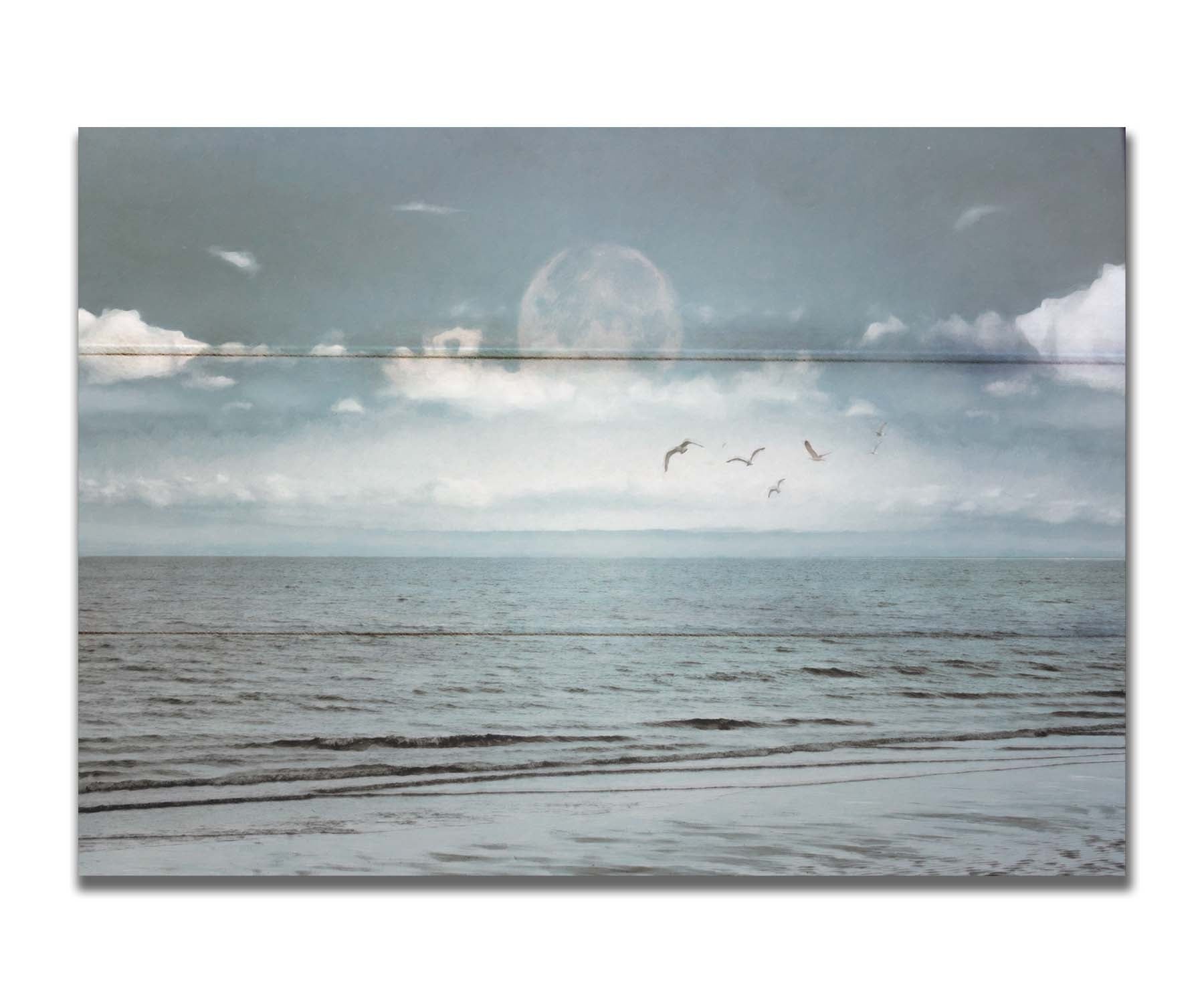 A photo of a pale blue sea with a lage moon on the horizon. Printed on a box board.