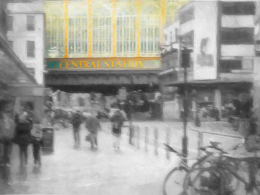 A photo taken from the streets of Glasgow, looking at the entrance to central station. The photo is in grayscale, with the exception of spot color on the face of the central station building.