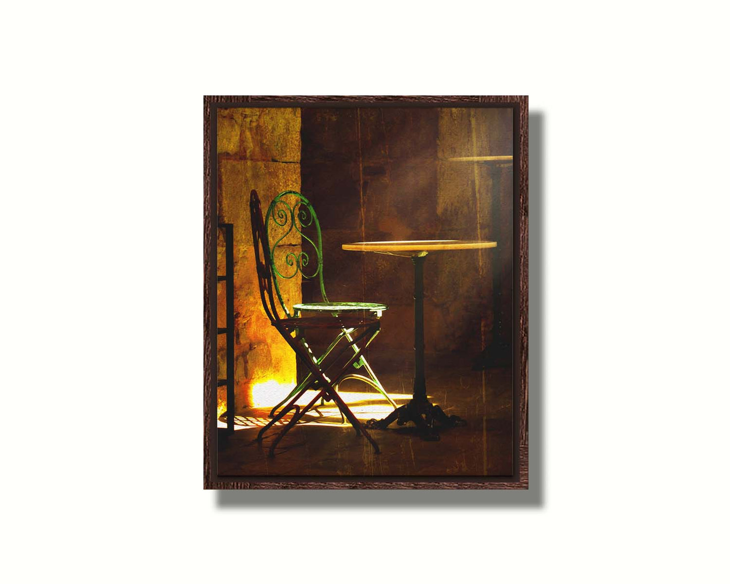 A photo of chairs around a small table, illuminated by light pouring in through the window. Printed on canvas in a float frame.