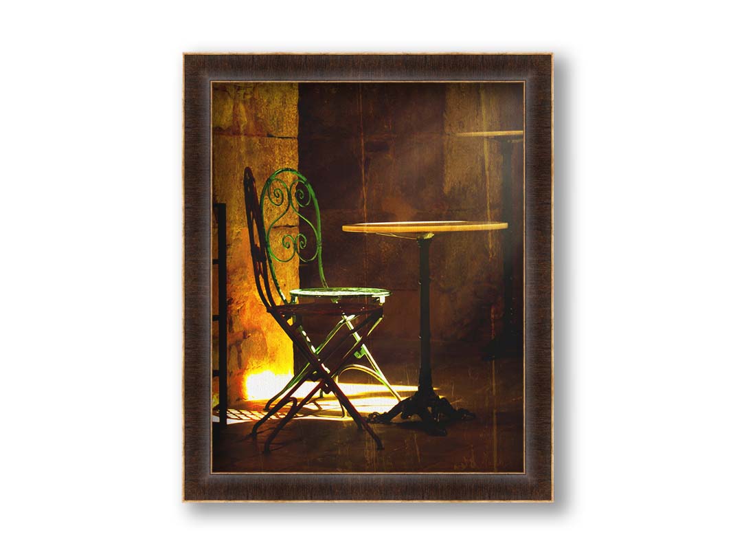 A photo of chairs around a small table, illuminated by light pouring in through the window. Printed on canvas and framed.